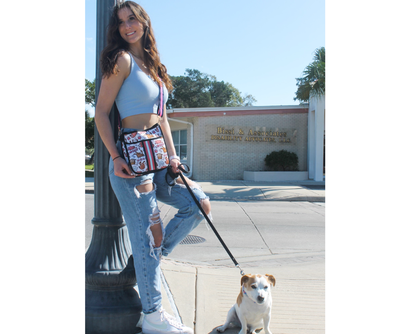 Dog walking bag worn crossbody with "Woof There It Is" pattern and pink striped trim