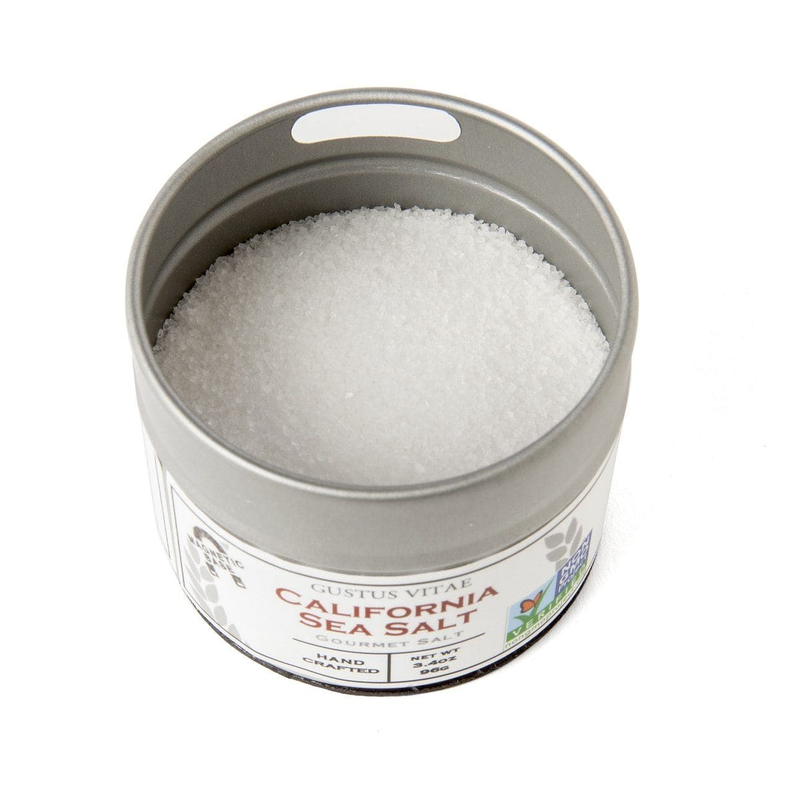Open round tin filled with fine white sea salt, silver rim and pull handle