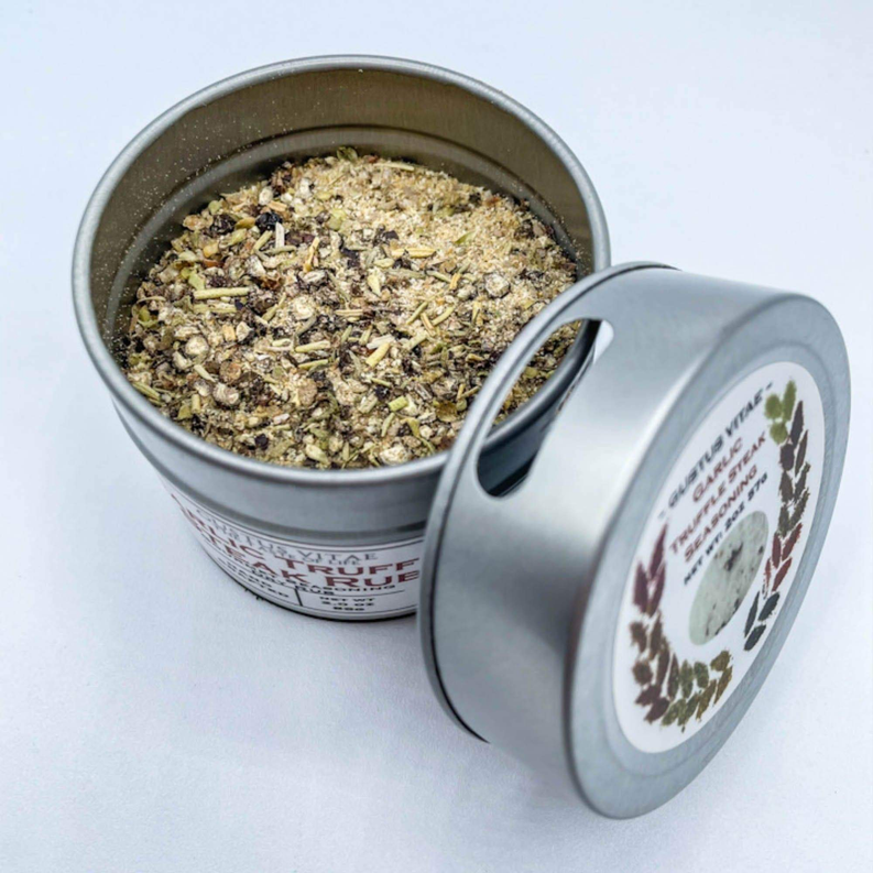 Garlic truffle steak rub tin open, filled with green-brown seasoning blend