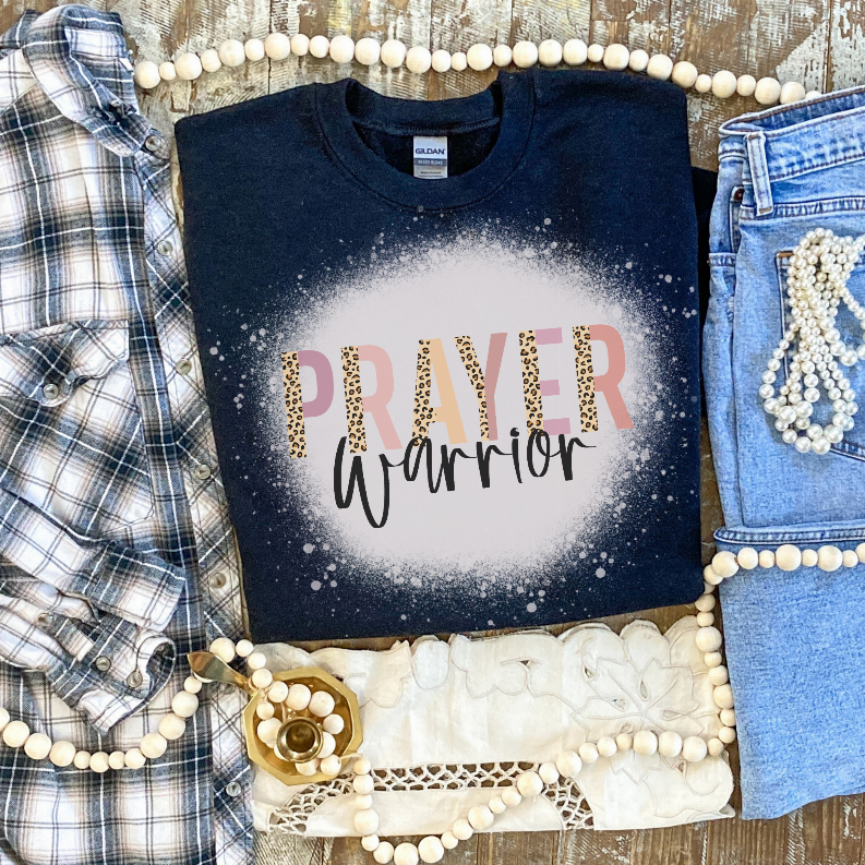 Navy bleached graphic T-shirt with 'Prayer Warrior' lettering inside speckled circle