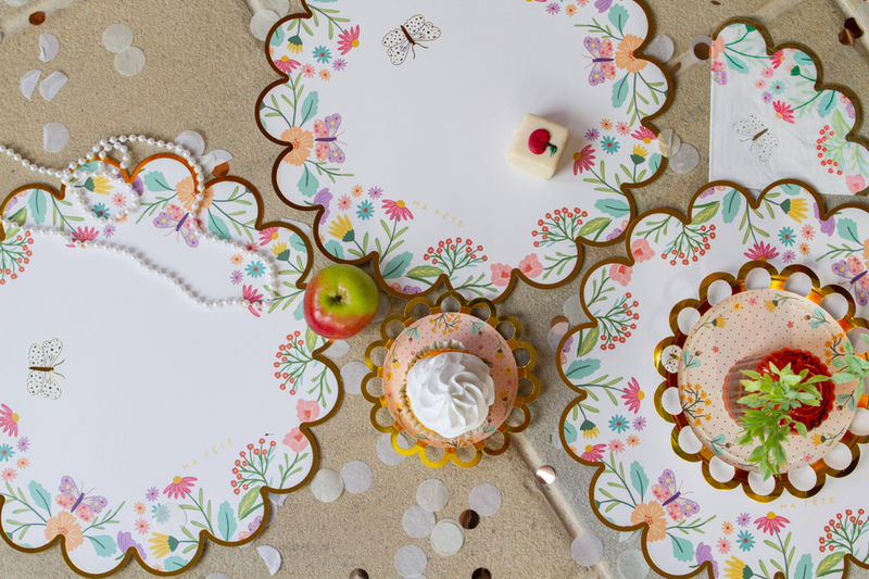 Round floral paper placemat with scalloped border and small butterfly and flower motifs