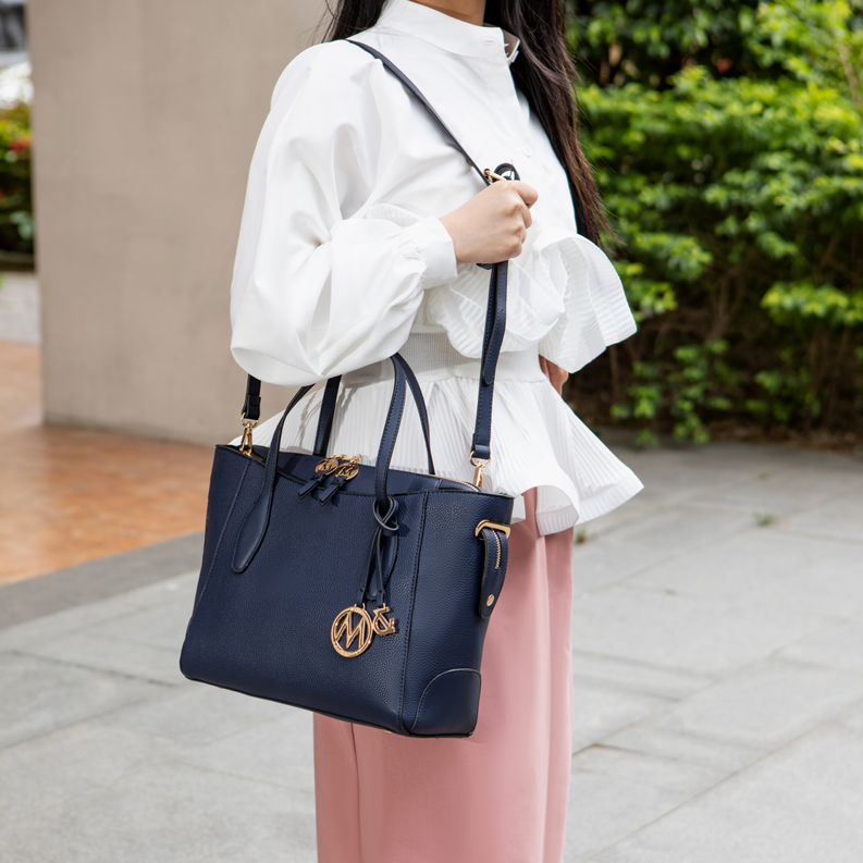 Dark vegan leather tote bag with shoulder strap and front logo charm