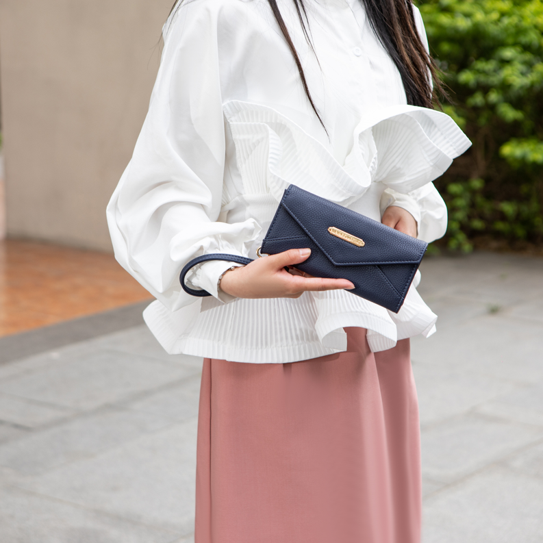 Dark vegan leather wallet clutch with gold-tone logo and snap flap