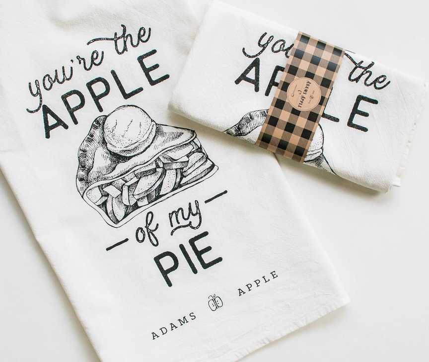 White flour sack towel with black apple pie illustration and text 'you're the APPLE of my PIE'