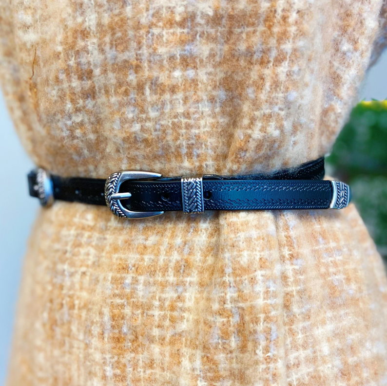 Close-up of double buckle leather belt, dark blue strap and silver buckle details.