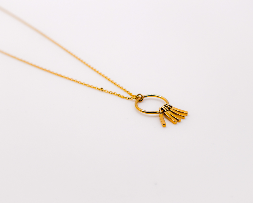 Gold chain necklace with round hoop pendant and three hanging tassels