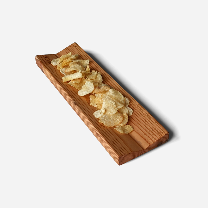 Rectangular wooden bowl tray with grooves, filled with thin potato chips