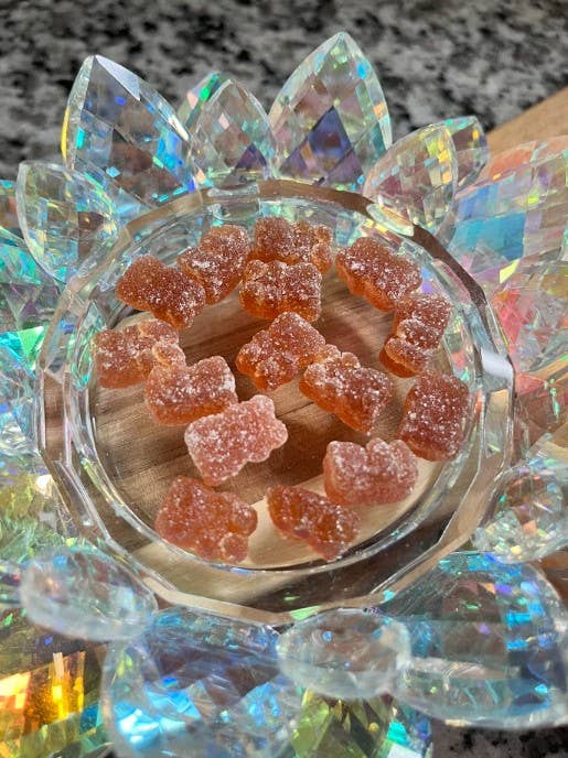 Orange multivitamin gummy pieces in a crystal glass dish
