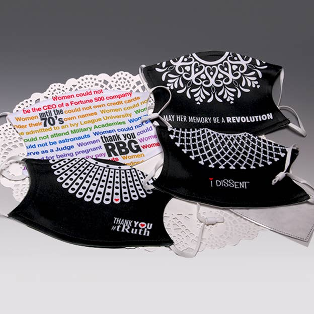 Pair of black face masks with white floral patterns, ear loops, and slogan text