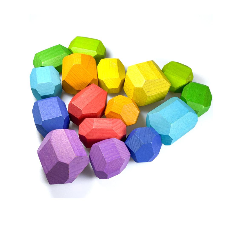 Set of multicolor wooden balancing stones in a loose pile on a white background