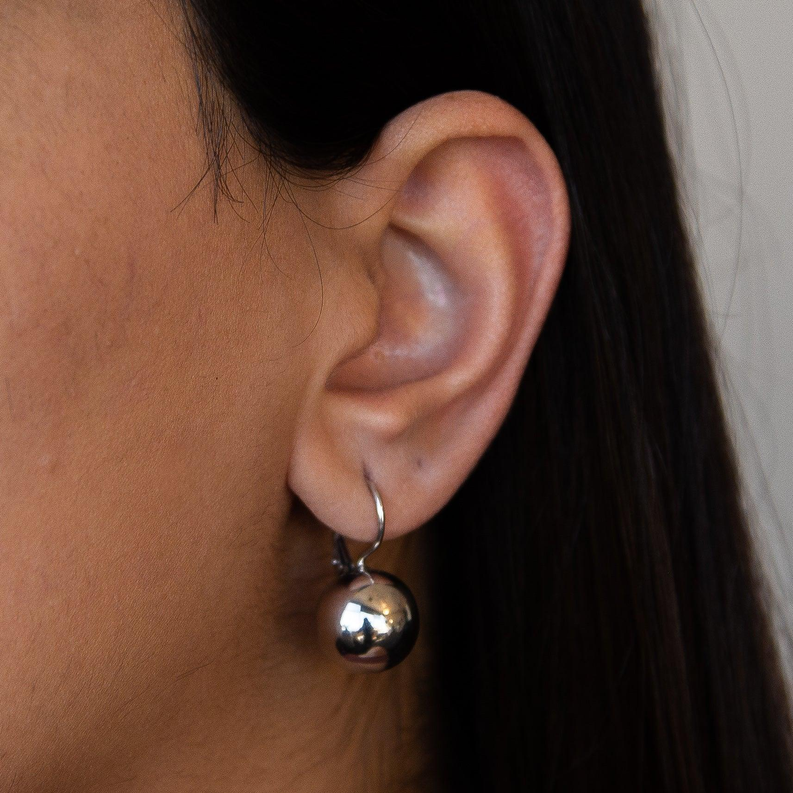 Silver sphere earwire earrings worn, reflective round spheres on curved hooks