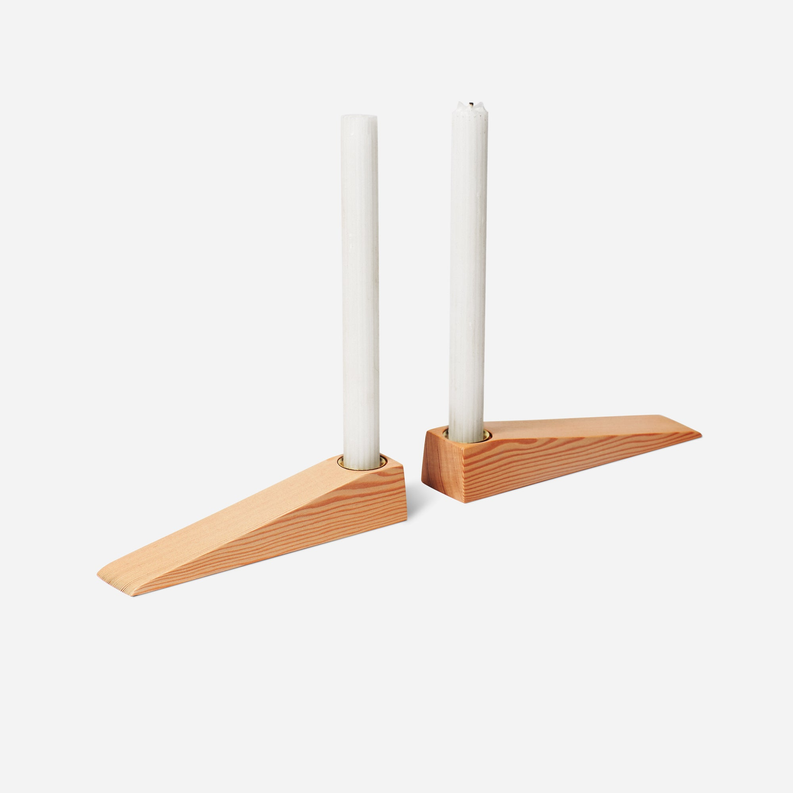 Wooden candle holder with two tall white candles and two black metal cups