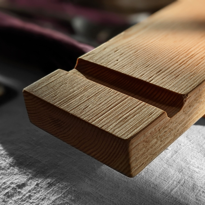 Wood charcuterie board with finger grooves and rounded edge ends.