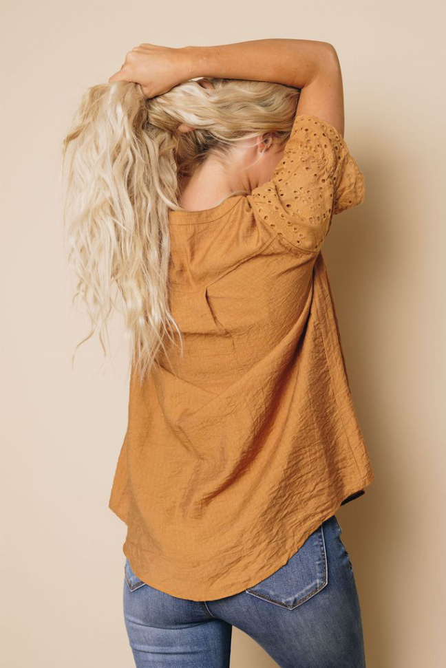 Rust brown pleated blouse with draped back and cutout eyelet sleeve detail