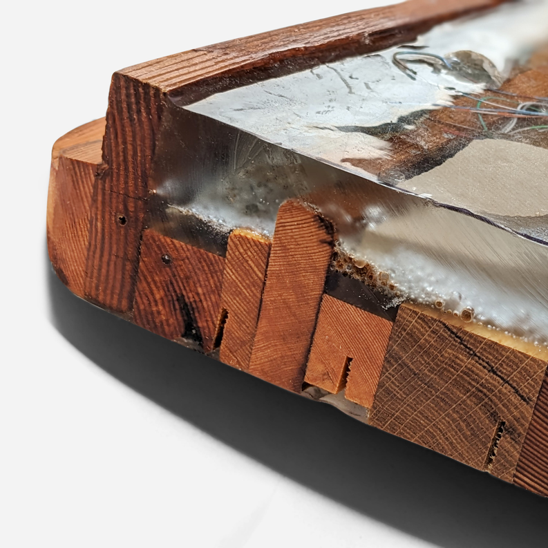 Wooden wall art with abstract metal and stone inlay, close-up corner.