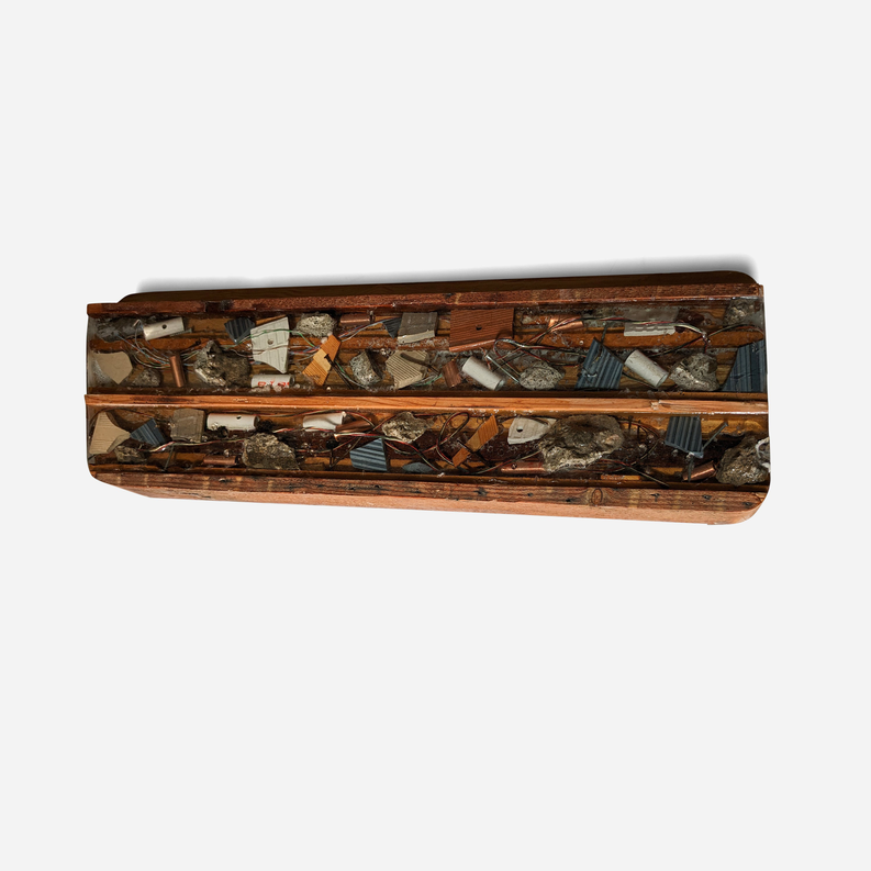 Wooden artwork panel with metal and stone collage, front-facing side view.