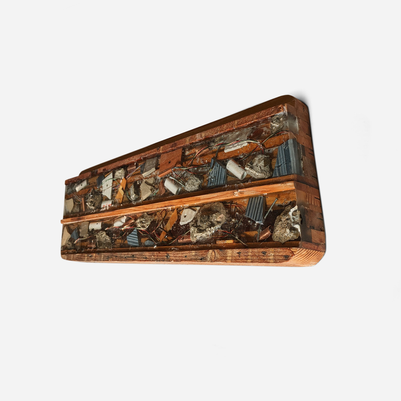 Rectangular wooden artwork with metal-and-stone collage, angled side view.