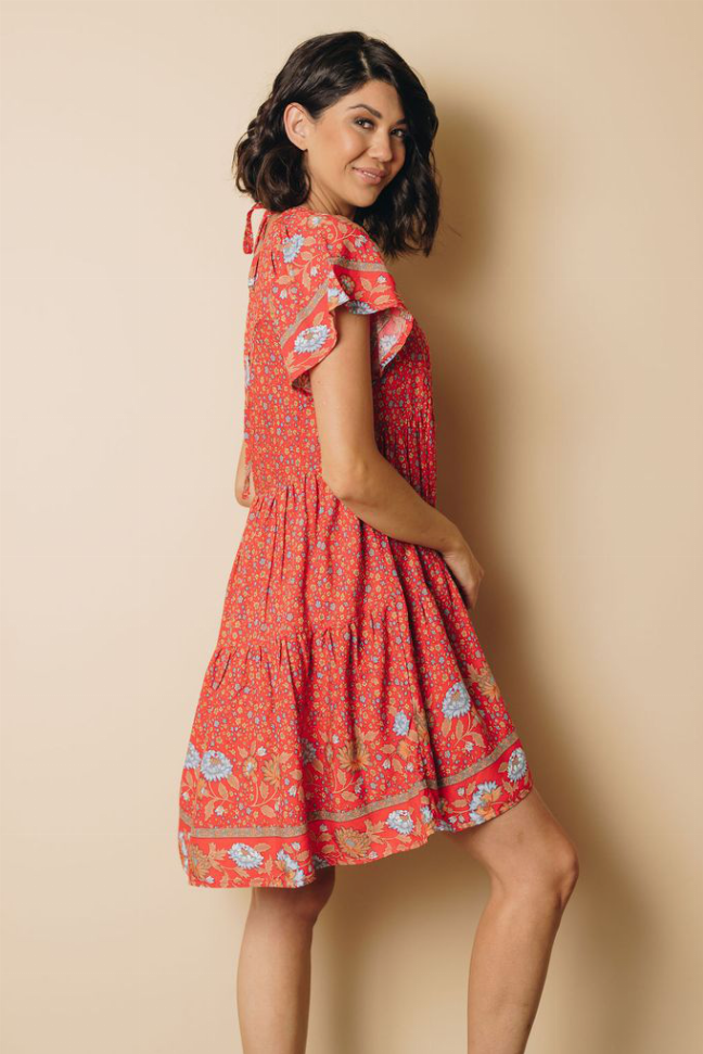 Red floral babydoll dress side view with flutter sleeves and gathered skirt