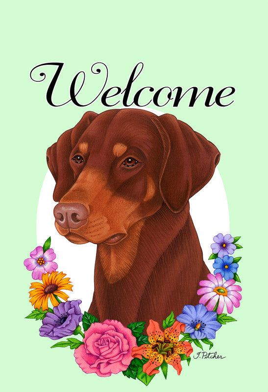 Red doberman garden flag with Welcome text, surrounded by colorful flowers and wreath