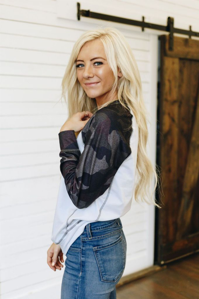 White crewneck pullover with dark camo raglan sleeves, close-up