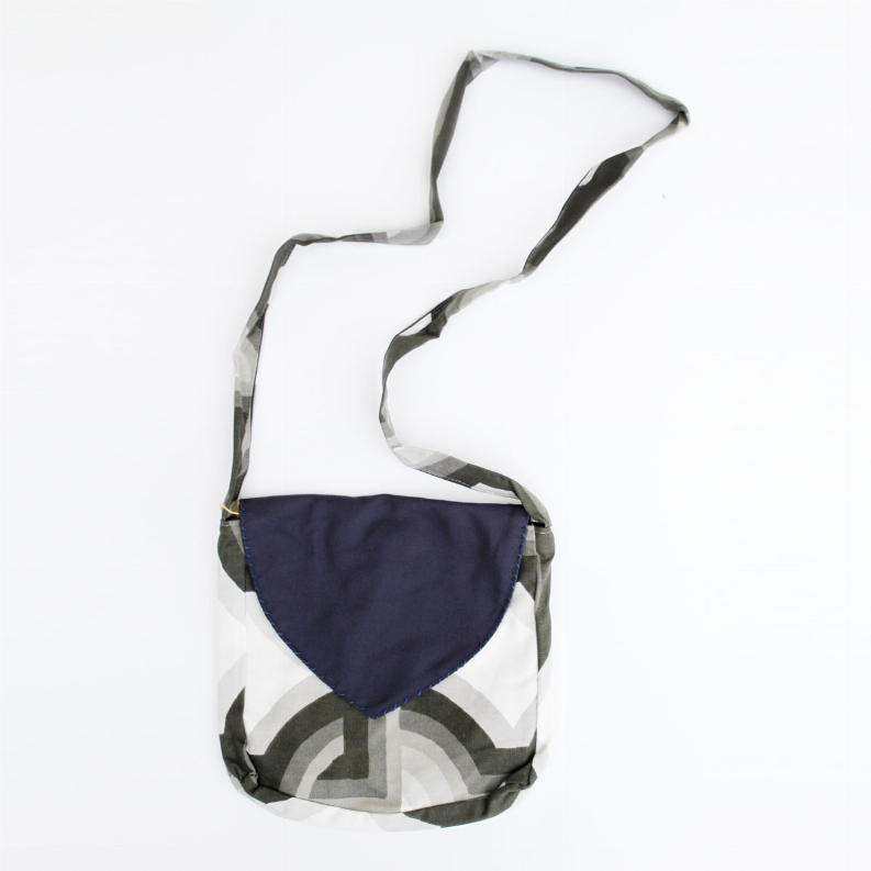 Geometric patterned boho shoulder bag with navy front pocket and cloth shoulder strap