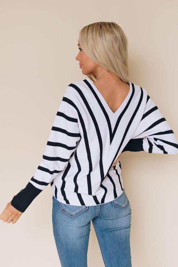Black-and-white striped V-neck sweater with ribbed cuffs and relaxed fit