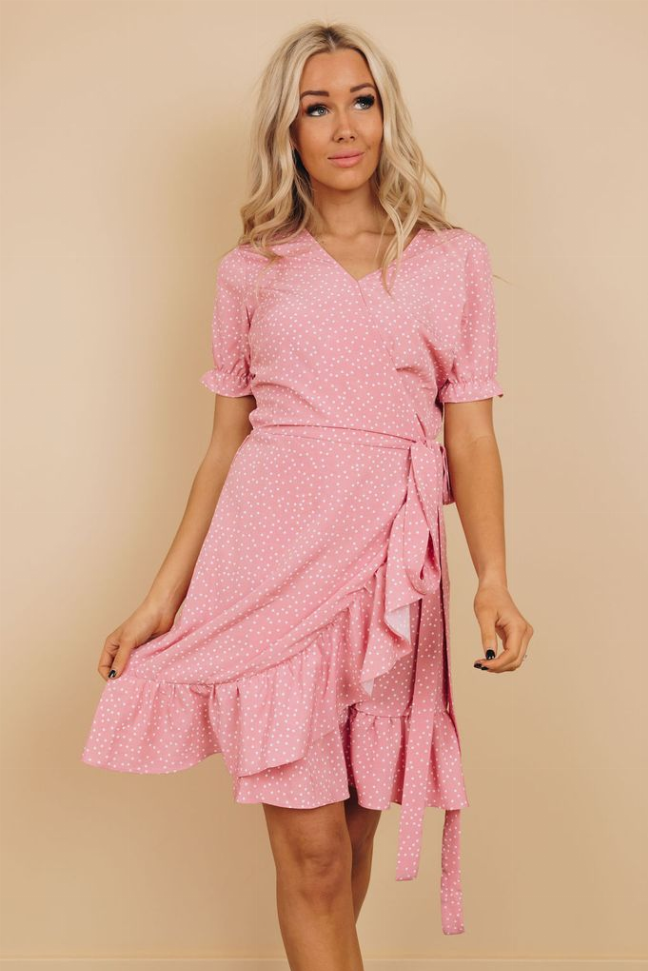 Pink dotted wrap dress with waist tie, V-neck, puff sleeves, and tiered ruffle skirt