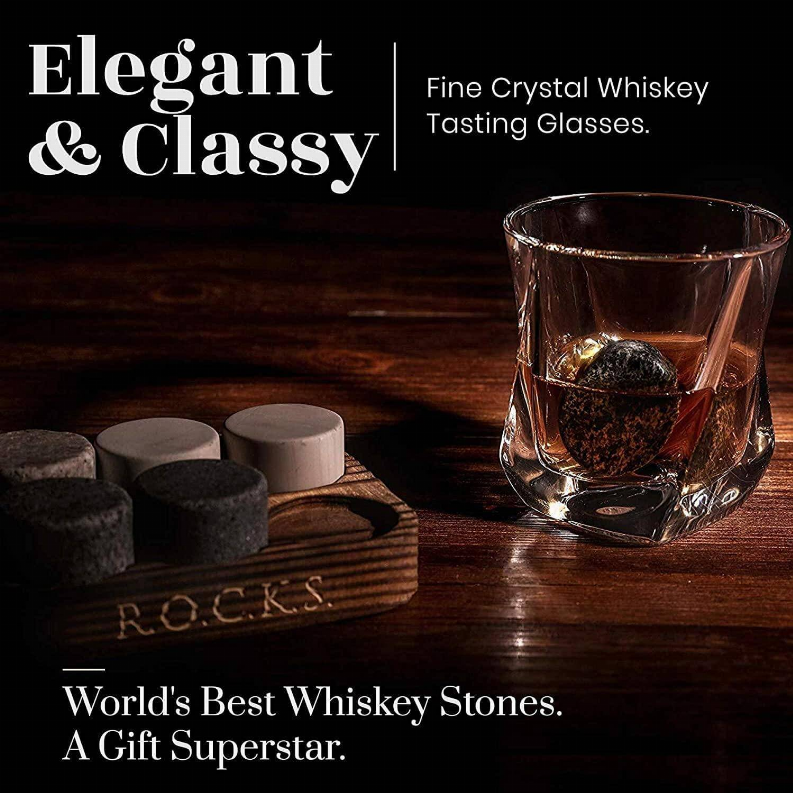 Whiskey chilling stones with clear tumbler on wooden surface