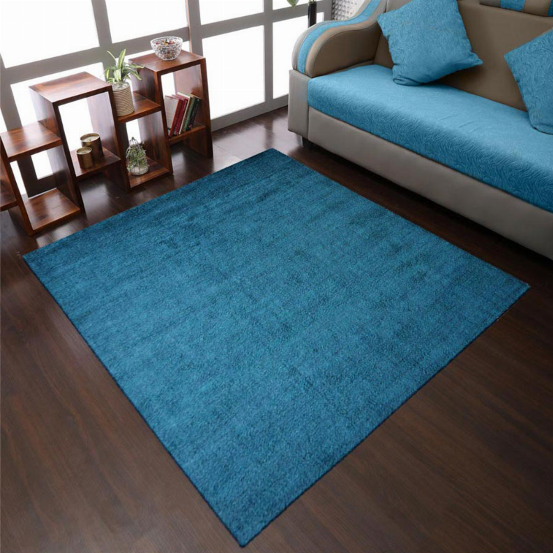 Blue square area rug over hardwood floor, textured pile with solid color