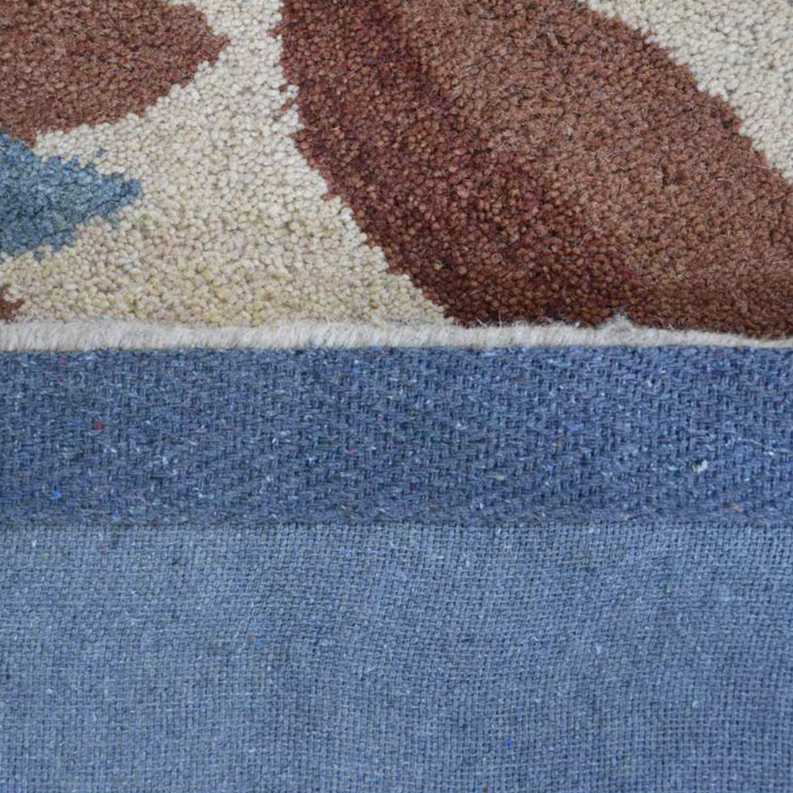 Hand-tufted shag area rug corner close-up with brown and cream pile and blue border