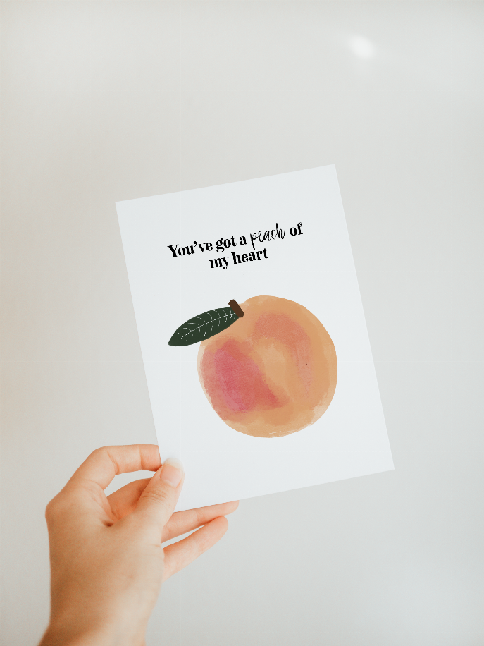 Angled greeting card held in hand, watercolor peach with leaf; text: You've got a peach of my heart