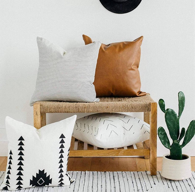 Set of 4 faux leather throw pillow covers: brown leather-look, striped white, and geometric white