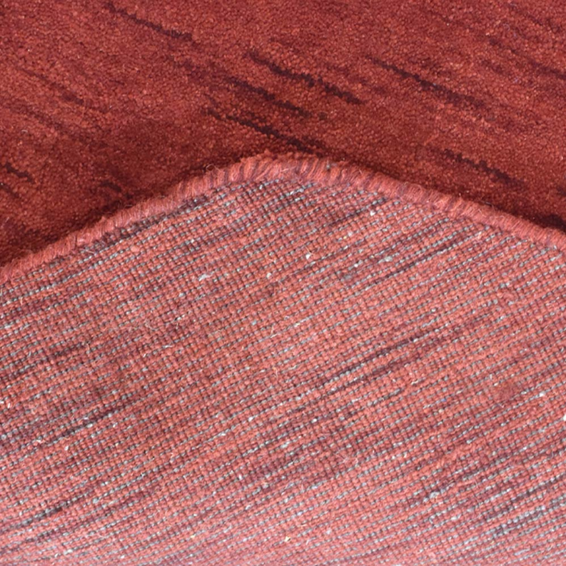 Red rug surface with light pink and striped texture, close-up