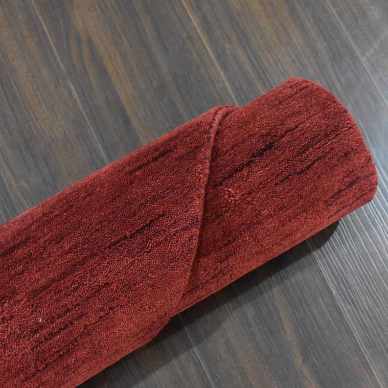Red octagon area rug, folded edge showing dense short wool pile