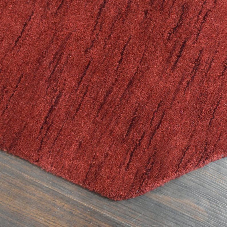 Red octagon wool rug corner close-up with textured pile and border