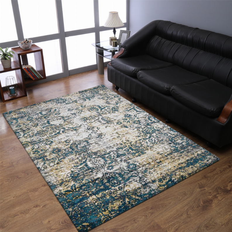 Abstract area rug in blue and beige with ornate pattern placed on wood floor