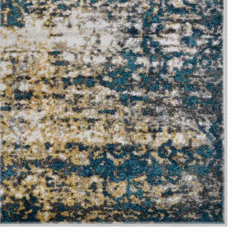 Close-up of abstract rug pattern in teal, blue, gray, and beige with faded texture