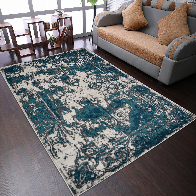 Abstract area rug with teal, blue, and white distressed damask-style pattern