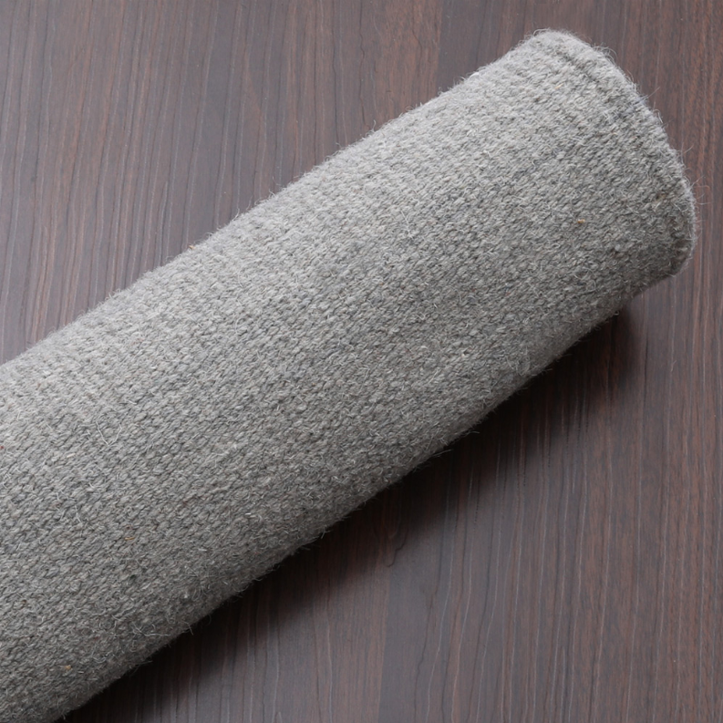 Gray flatweave wool rug texture with rolled edge and dense weave.