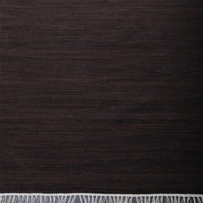 Dark brown flat weave rug close-up with subtle horizontal texture and cream fringe edge.