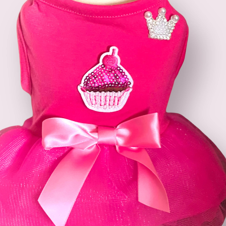 Hot pink dog party dress with cupcake patch, jeweled crown, and satin bow.