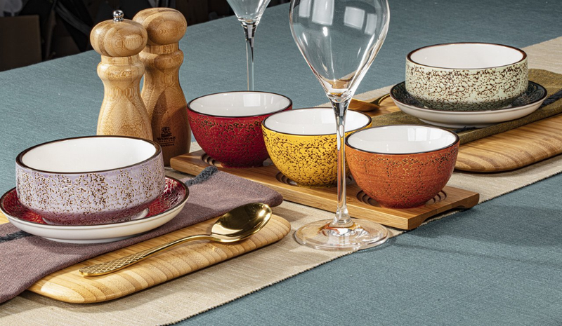Assorted speckled ceramic bowls with white interiors, multiple colors and sizes