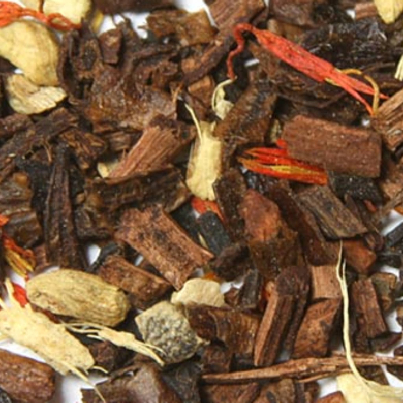 Close-up of dark tea leaves with cinnamon and orange peel pieces