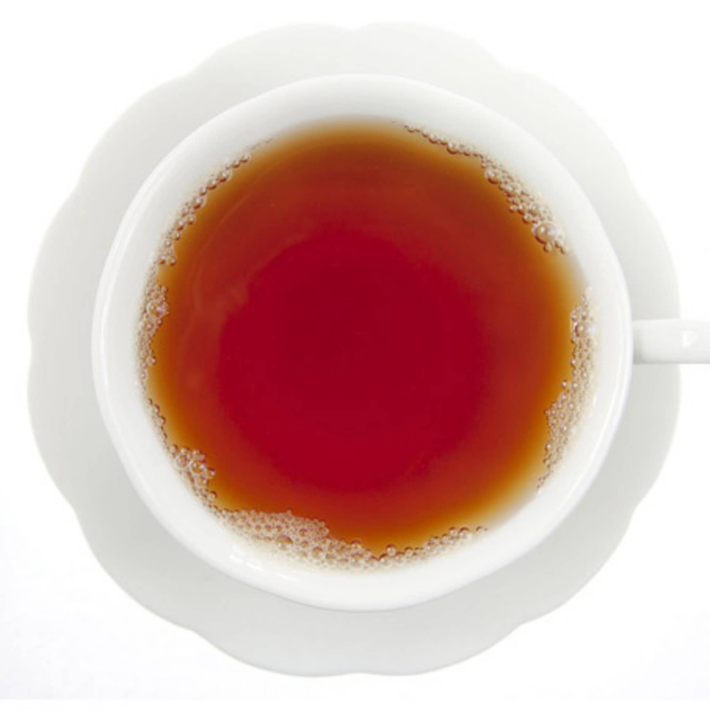 Cup of hot spiced tea with amber-red surface