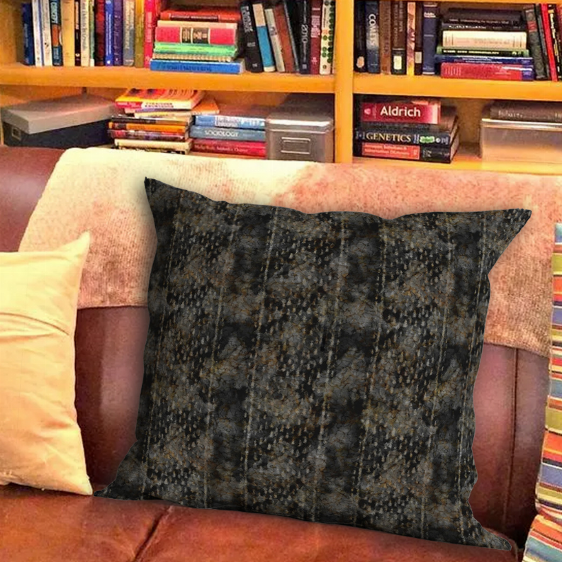 Square throw pillow on sofa, dark charcoal textured abstract fabric