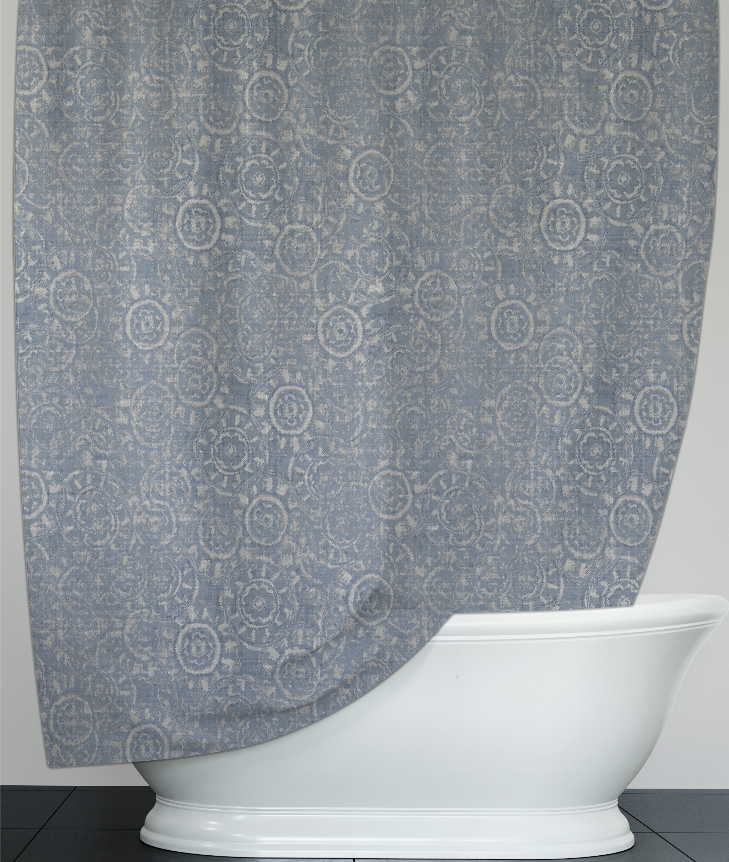 Blue patterned shower curtain with repeating circular medallions, draped over tub