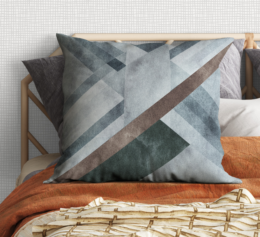 Decorative pillow with muted blue and gray triangular blocks and brown diagonal line.