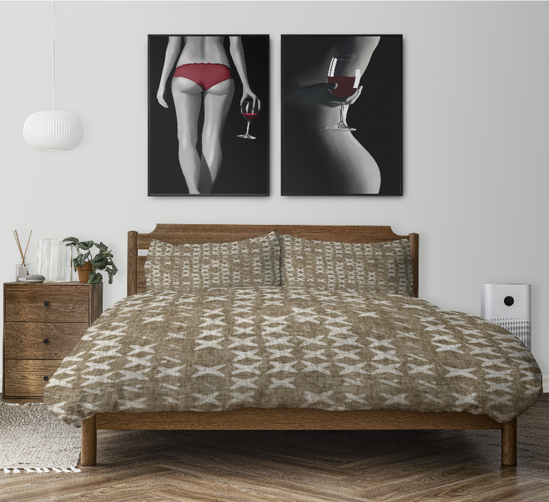 Taupe comforter and pillow shams with white geometric print on a bed