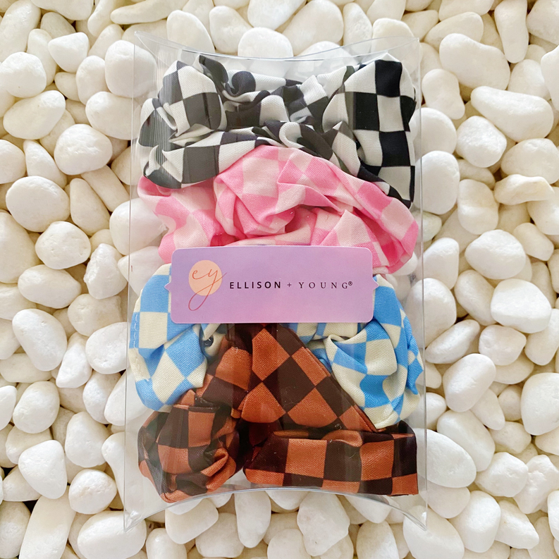 Set of 4 checkerboard hair scrunchies in clear bag: black/white, blue, pink, brown.