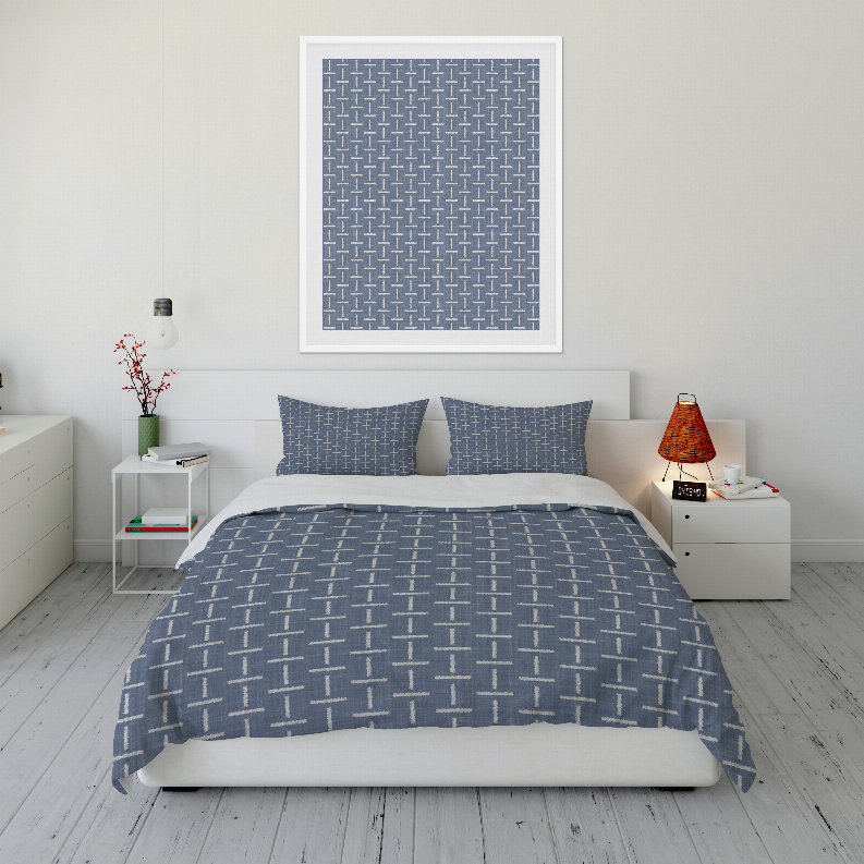 Blue geometric comforter set with two pillow shams, spread over white base